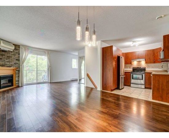 A spacious kitchen with wooden cabinets and a stainless steel refrigerator.