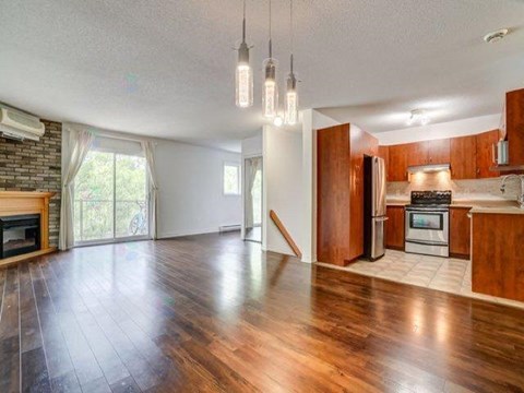 A spacious kitchen with wooden cabinets and a stainless steel refrigerator.