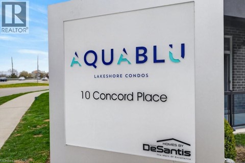 A sign for a condominium complex called Aquablu is displayed in front of a building.