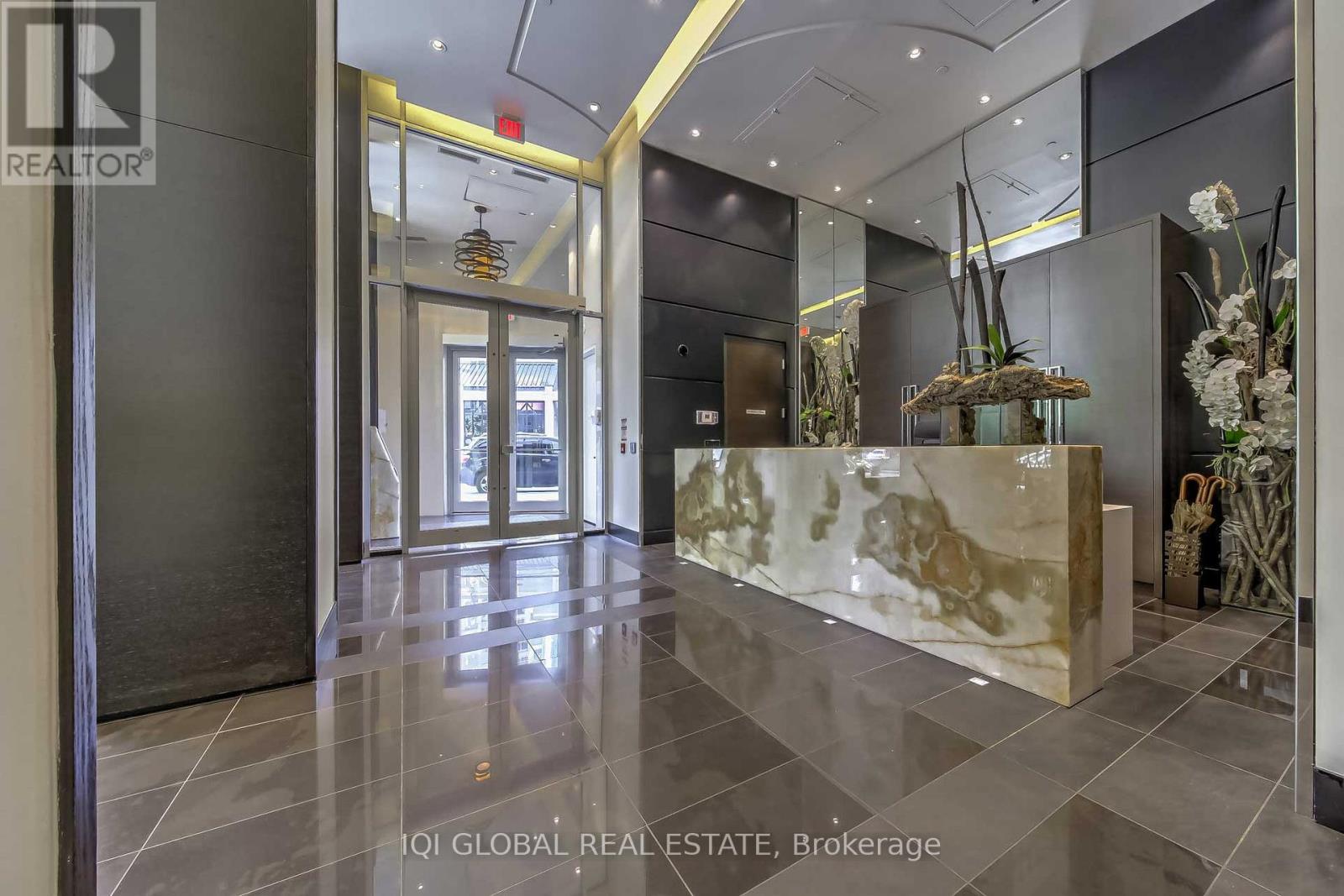A hallway with a marble counter and a glass door.