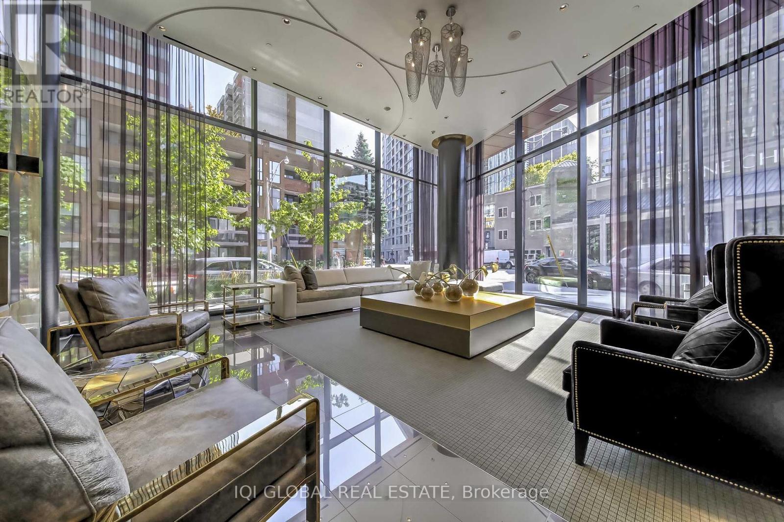 A modern living room with a glass wall and a view of the city.