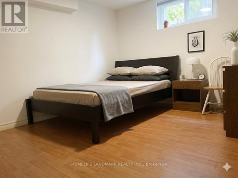 A bedroom with a bed, nightstand, and lamp.