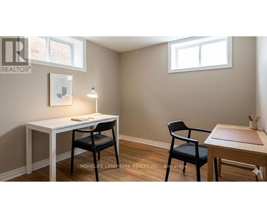 A room with a desk, chair and a table with a chair.