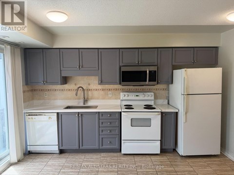 A kitchen with white appliances and grey cabinets.