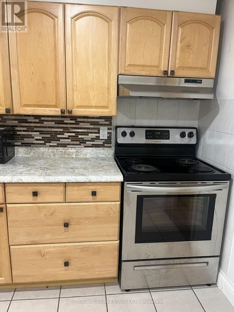 A kitchen with wooden cabinets and a stove top oven.