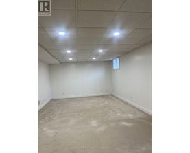A spacious empty room with a white ceiling and walls.