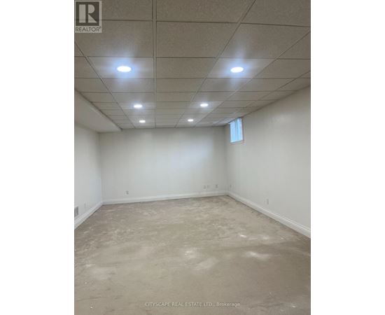 A spacious empty room with a white ceiling and walls.
