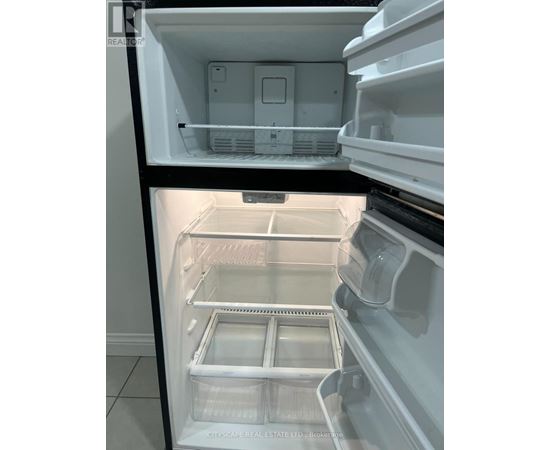 A white refrigerator with the door open showing the empty shelves.