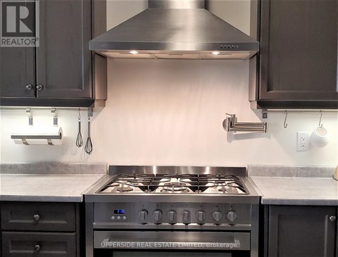 A modern kitchen with a stove top oven and a range hood.