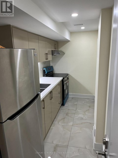 A kitchen with a stainless steel refrigerator and a tile floor.