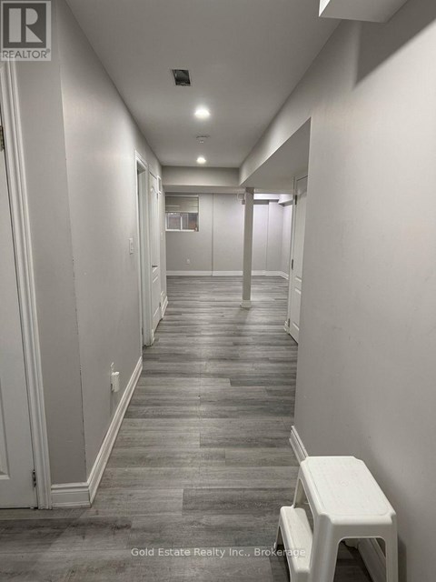 A long hallway with a white stool in the middle.