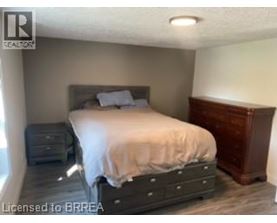A bedroom with a bed, nightstand, and dresser.