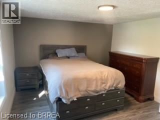 A bedroom with a bed, nightstand, and dresser.
