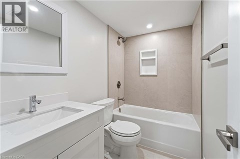 A white bathroom with a toilet, sink, and bathtub.