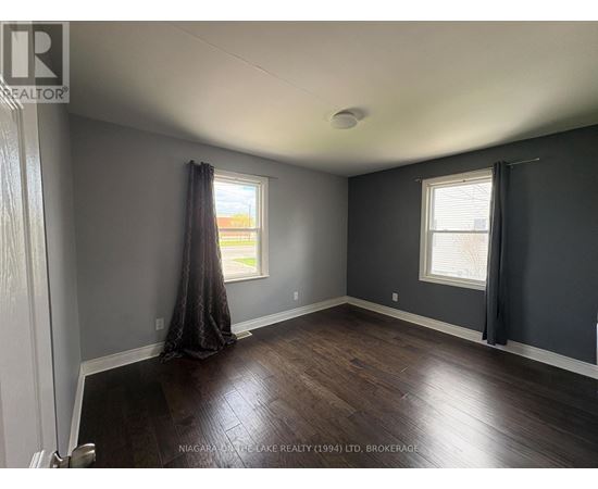 A room with a window and a curtain.