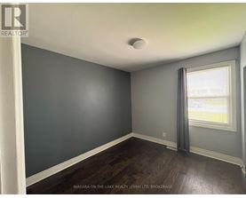 A room with a window and a grey curtain.