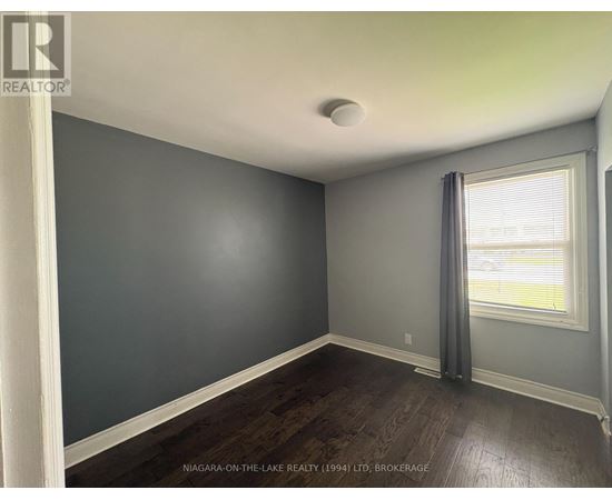 A room with a window and a grey curtain.