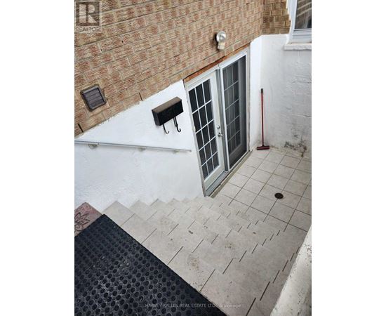 A small balcony with a metal railing and a glass door.