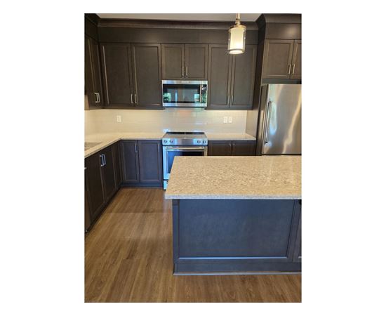 A kitchen with a stove top oven and a refrigerator.