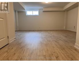 A room with wooden flooring and a window.