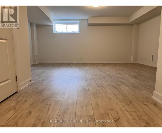 A room with wooden flooring and a window.