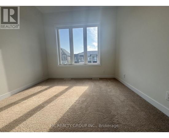 A room with a large window and carpeted floor.