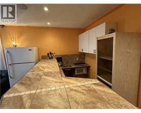 A kitchen with a refrigerator, microwave, and oven.