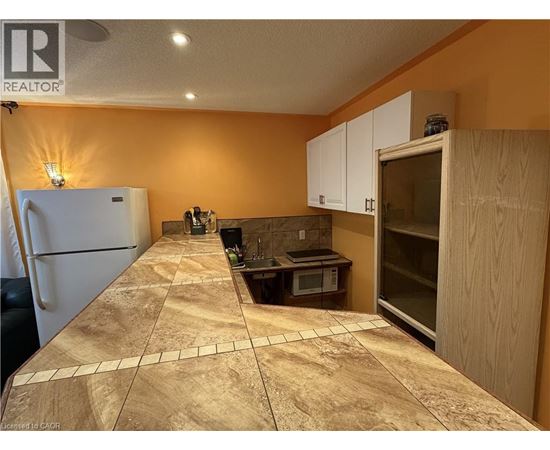 A kitchen with a refrigerator, microwave, and oven.