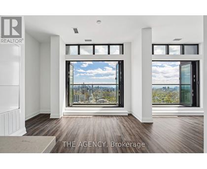 A real estate agency showcases a spacious room with a view of the cityscape through large windows.