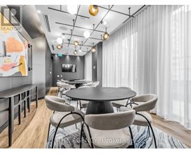 A modern dining room with a round table and chairs.