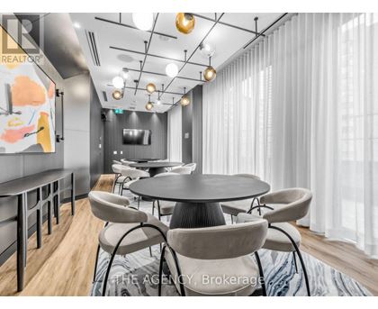 A modern dining room with a round table and chairs.