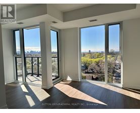 A room with a view of the city through large windows.