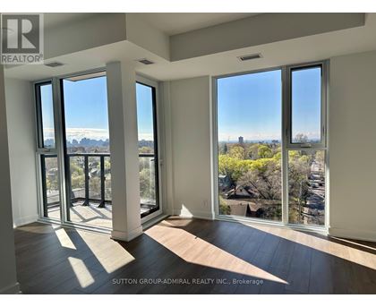 A room with a view of the city through large windows.