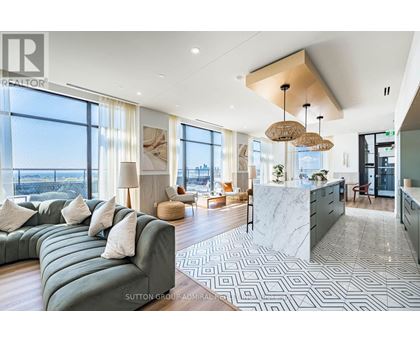 A modern living room with a large green sofa and a marble countertop.
