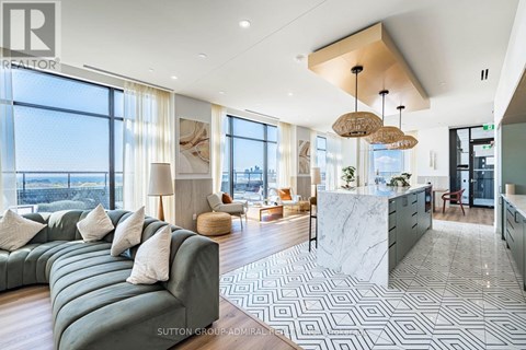 A modern living room with a large green sofa and a marble countertop.