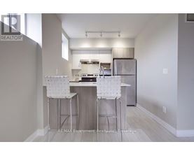 A kitchen with white chairs and a white counter top.