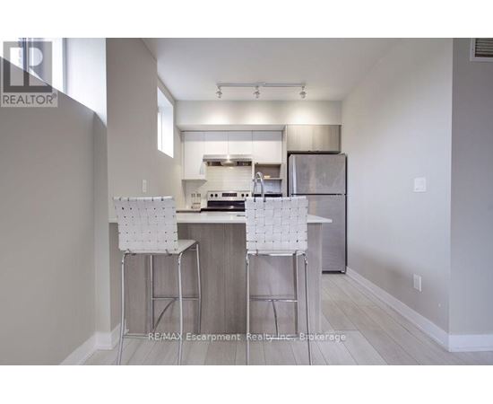 A kitchen with white chairs and a white counter top.