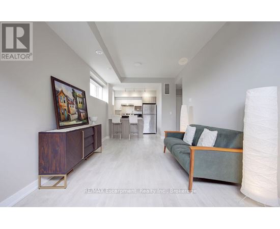 A living room with a couch, a side table, and a painting on the wall.