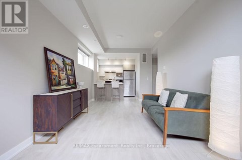 A living room with a couch, a side table, and a painting on the wall.
