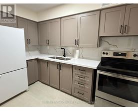A kitchen with a white fridge, brown cabinets, and a black stove top oven.