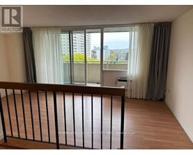 A balcony with a railing overlooking a cityscape.