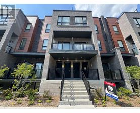 A multi-story apartment building with a "For Sale" sign in front.