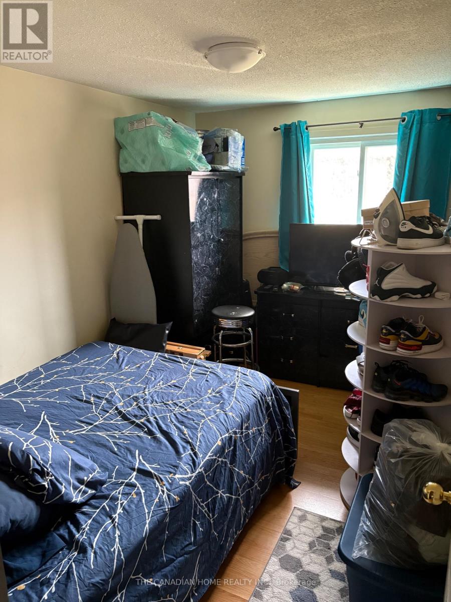 A bedroom with a bed covered in a blue spider web print sheet.