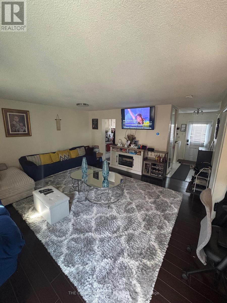 A living room with a grey rug and a blue couch.