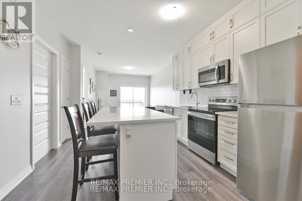 A kitchen with white cabinets and a stainless steel refrigerator.