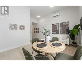 A dining room with a table set for four and a green chair.