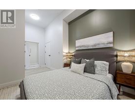 A bedroom with a large bed and a painting on the wall.