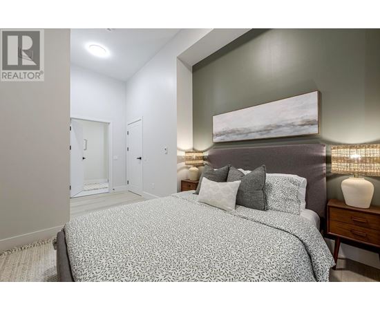 A bedroom with a large bed and a painting on the wall.
