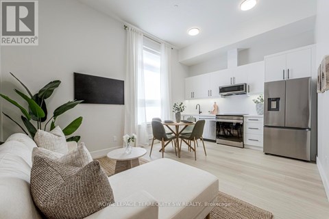 A modern living room with a white couch and a television mounted on the wall.