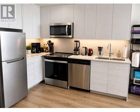 A modern kitchen with stainless steel appliances and white cabinets.